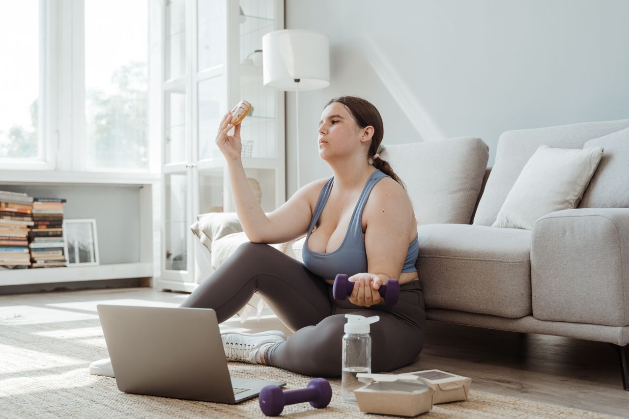Plus-size woman exercising and making healthy choices in a cozy living room.